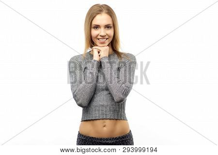 Beautiful Young Joyful Woman Keeps Hands Together, Has Brown Eyes Full Of Happiness, Stands Against 
