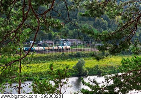 Kungur, Perm Region, Russia - August, 8 2020: Long Multicolored Freight Train Goes Along Chusovaya R