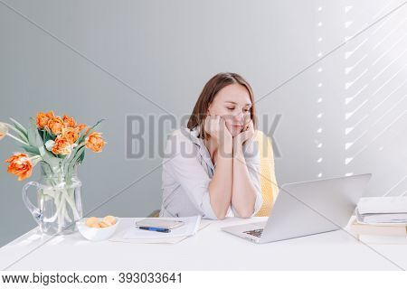 Bored Middle Age Woman Sitting At Desktop Table Working On Laptop Computer. Tired Young Woman Learni