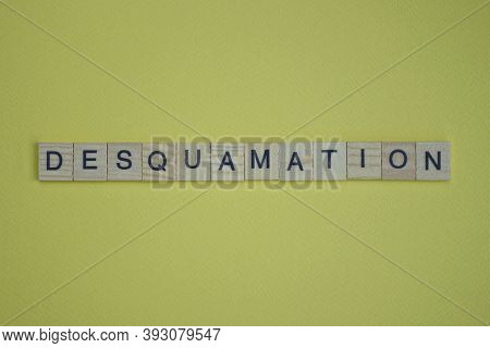 Word Desquamation Made From Wooden Letters Lies On A Yellow Table