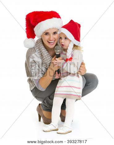 ภาพเหมือนคริสต์มาสของแม่มีความสุขและเด็กสาวร้องใน Mi