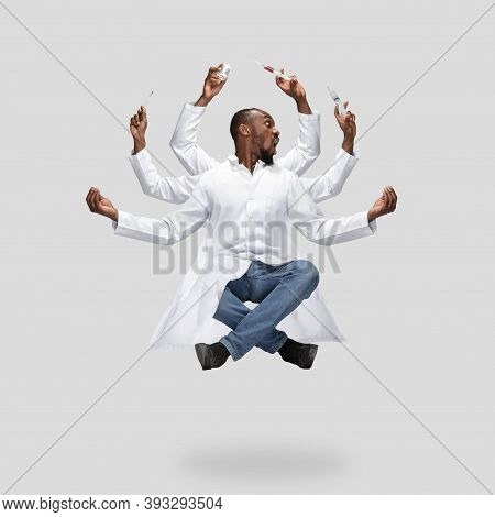Handsome African Doctor, Multi-armed Man Levitating Isolated On Grey Studio Background With Equipmen
