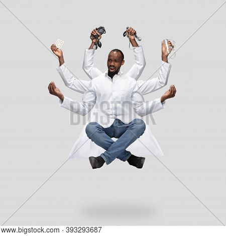 Handsome African Doctor, Multi-armed Man Levitating Isolated On Grey Studio Background With Equipmen
