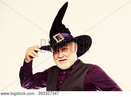 Mature Man Magician In Witch Hat. Bearded Man Ready For Halloween Party. Evil Wizard. Stargazer Or A