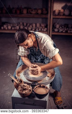 Charming Pottery Woman Making Ceramic Pot On The Pottery Wheel . Pottery Workshop.