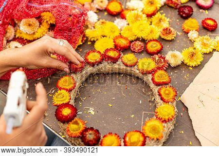 Florist Stick Yellow And Red Xeranthemum Onto The Wreath