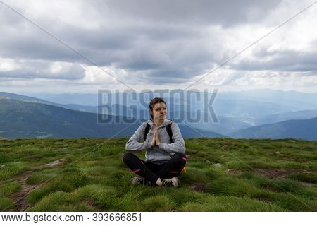 Young Girl On The Grass, Surrounded By Beautiful Mountains. Tourism. Travels.