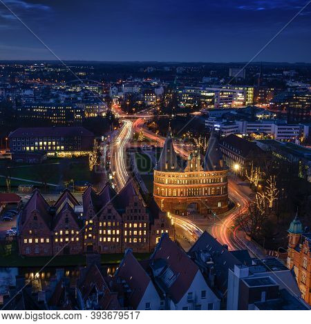 Luebeck, Germany - December 17, 2019:  Aerial Night View Over The Illuminated Holstentor And Histori