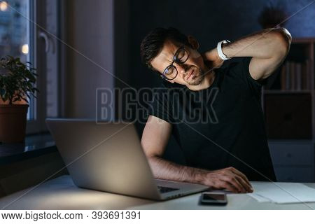 Tired Stressed Young Businessman Suffering From Neckpain Working From Home Office Sitting At Table W