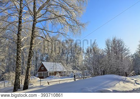 Old Wooden Village House On The Edge Of Winter Forest With Lacy Crowns Of Snow-covered Trees. Beauti