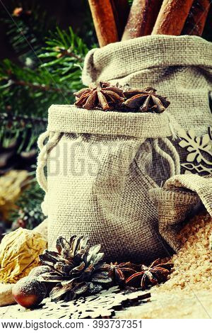 Christmas Atmosphere: Spices, Candies, Cones And Nuts With Fir Paws On A Vintage Wooden Background, 