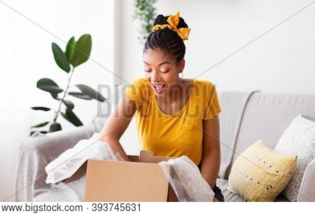 Happy Customer Concept. Portrait Of Excited Black Woman Opening And Unpacking Cardboard Box Parcel, 