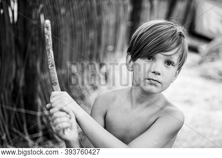 Portrait Of Cheerful Boy Lying In Hay. The Boy Advertises Childrens Clothes For The Autumn. Happy Ch