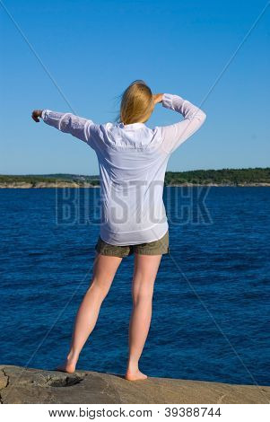 Donna in piedi al litorale e mostrando qualcosa