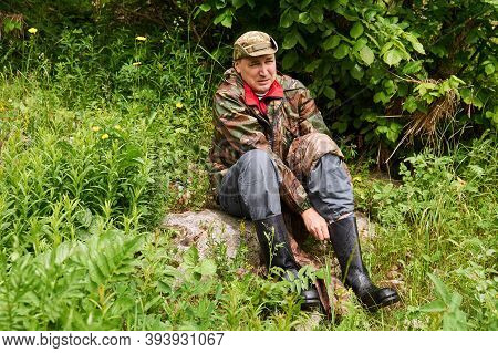 Man Traveler Dressed In Military Style, Changing Boots Using A Footwraps Instead Of A Sock