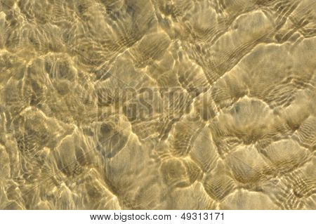 Ripples น้ำไหลผ่านทรายสีเหลืองมีลวดลายพื้นผิวหรือพื้นหลัง