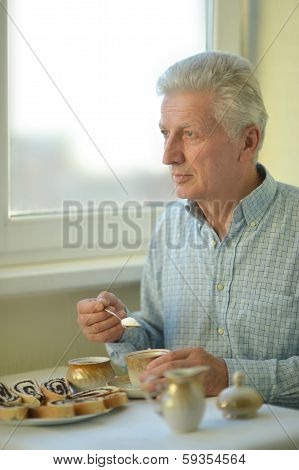 Elderly man with cup of tea