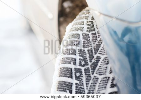 transportation, winter and vehicle concept - closeup of car winter tire