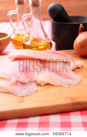 Raw fish tilapia on cutting board and spices