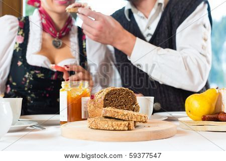 Couple in a traditional mountain hut having a hearty breakfast