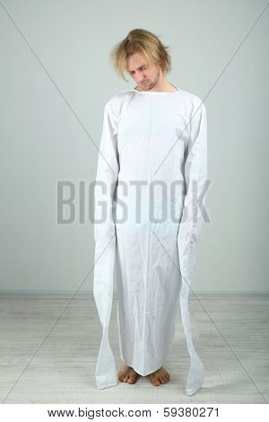 Mentally ill man in strait-jacket on gray background