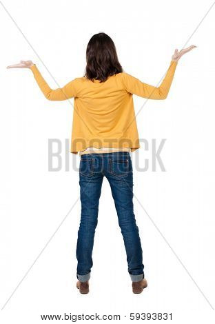 Back view of Beautiful business woman in yellow pulover looking at wall and Holds a hand up.  young brunette girl standing. Rear view people. Isolated over white background. 
