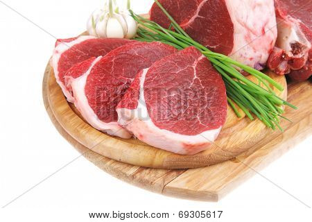 butchery : fresh raw beef lamb big rib and fillet ready to cooking with green stuff on wooden plate isolated over white background
