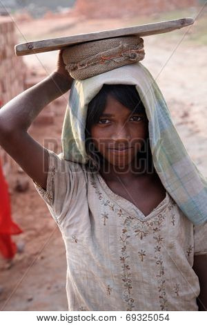 SARBERIA,INDIA, JANUARY 16: Brick field workers carrying complete finish brick from the kiln. Tools and machines for making bricks are very rudimentary, Jan 16, 2009 in Sarberia, West Bengal, India.