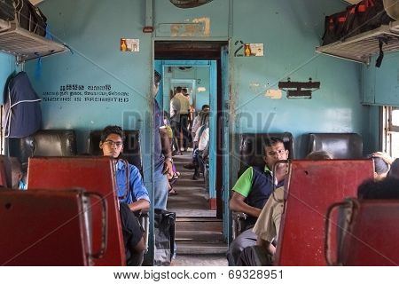 HIKKADUWA, SRI LANKA - MARCH 12, 2014: Commuters sitting in train to Colombo. Trains are very cheap and poorly maintained but it's the best option to witness a bit of everyday local life.