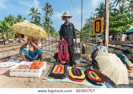 HIKKADUWA, SRI LANKA - FEBRUARY 23, 2014: Local street vendors selling mats by the railroad. The Sunday market is a fantastic way to see Hikkaduwa's local life come alive.