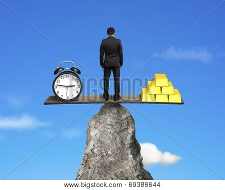 Man Standing On Board Balace With Clock And Gold