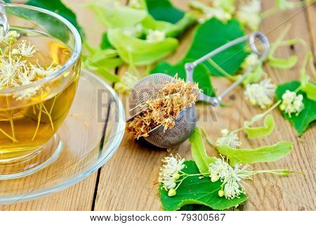 Herbal tea of linden flowers in strainer with cup