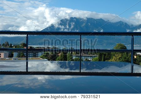 Mountains At Geneve Lake Reflected In Water On Table.