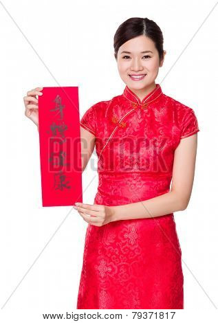 Woman with traditional cheongsam and holding Fai Chun, phrase meaning is blessing for good health