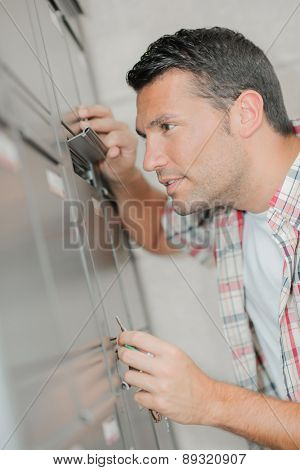 Man looking through flap of post office box
