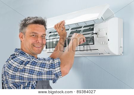 Male Technician Repairing Air Conditioner