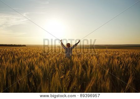 Woman Stands In A Field Of Ripe Wheat