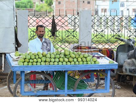 A Man Sells Fruits From A Stall In Delhi