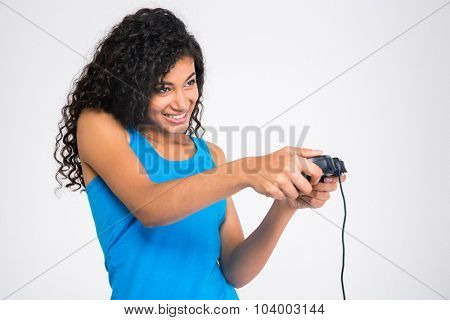 Portrait of a cheerful afro american woman playing in video game with joystick isolated on a white background