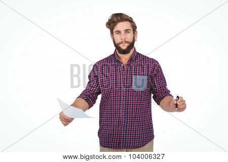 Portrait of confident hipster holding pen and paper standing against white backgroiund