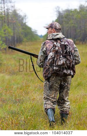 Hunter In Camouflage Shooting On The Forest Edge