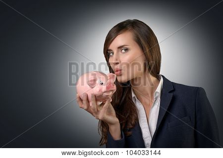 Successful Businesswoman Kissing Her Piggy Bank