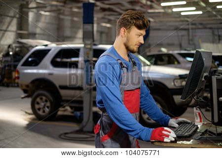 Specialist near car diagnostic pc in a workshop 