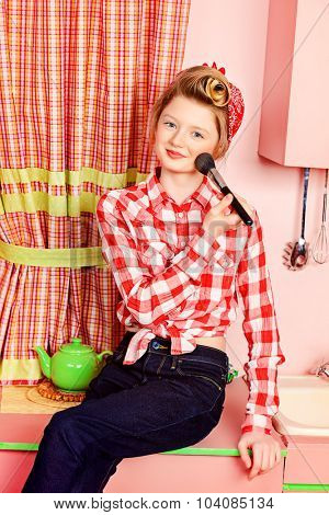 Pretty pin-up girl teenager smarten up on a pink kitchen. Beauty, youth fashion. Pin-up style.