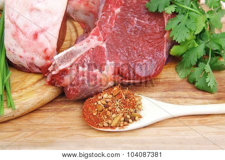 raw meat : fresh beef pork big rib and fillet with garlic and green stuff on wood isolated over white background