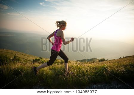 Beautiful Young Woman Runns Cross Country On A Mountian Path At Sunrise