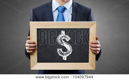 Unrecognizable businessman holding blackboard with drawn dollar concept