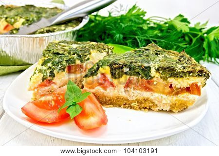 Pie celtic with spinach and tomato in plate on table