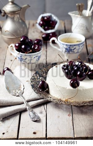 Cheesecake with cherries on a wooden table.