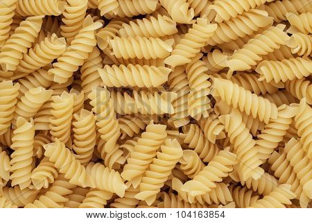 close-up of dry uncooked rotini texture background